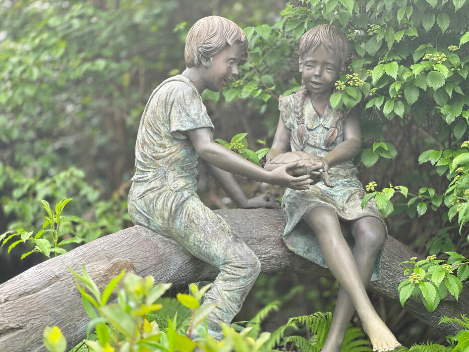 Two kids on log statue